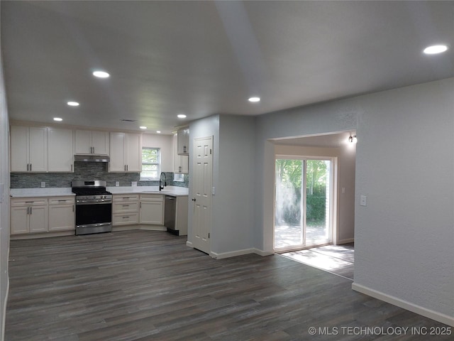 12623 E 19th St, Tulsa, OK 74128 - kitchen featuring stainless steel appliances, under cabinet range hood, light countertops, dark wood finished floors, and decorative backsplash