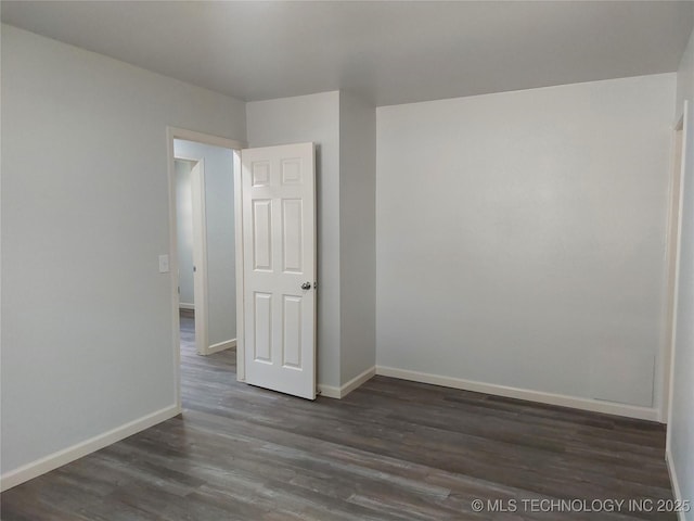 12623 E 19th St, Tulsa, OK 74128 - spare room featuring dark wood-type flooring and baseboards