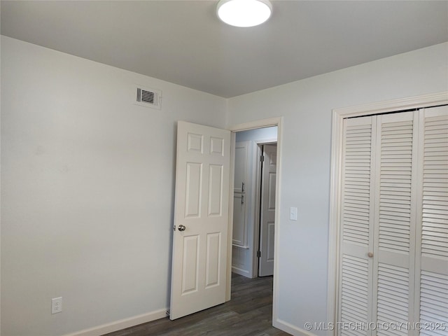 12623 E 19th St, Tulsa, OK 74128 - unfurnished bedroom featuring dark wood-style flooring and a closet