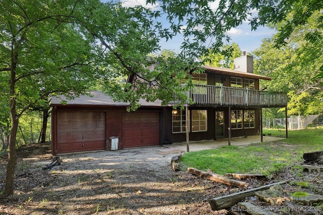 905 W Andrew Ave, Sapulpa, OK 74066 - back of property with a chimney, a deck, driveway, and an attached garage