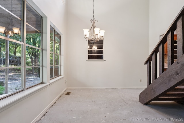 905 W Andrew Ave, Sapulpa, OK 74066 - unfurnished dining area with a chandelier, a high ceiling, and concrete flooring