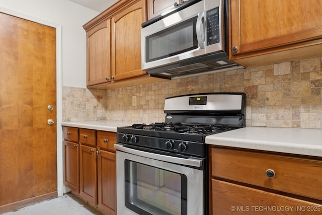 905 W Andrew Ave, Sapulpa, OK 74066 - kitchen featuring stainless steel appliances, backsplash, brown cabinetry, and light countertops