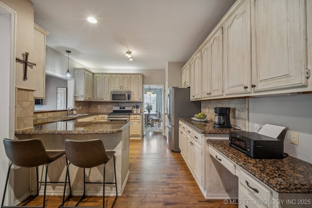 11902 N 150th E Ave, Collinsville, OK 74021 - kitchen featuring stainless steel appliances, backsplash, dark wood-style flooring, and a peninsula