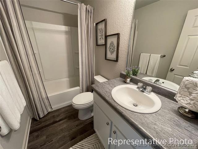 23260 E 115th St S, Broken Arrow, OK 74014 - full bathroom featuring wood finished floors, vanity, and shower / bathtub combination with curtain