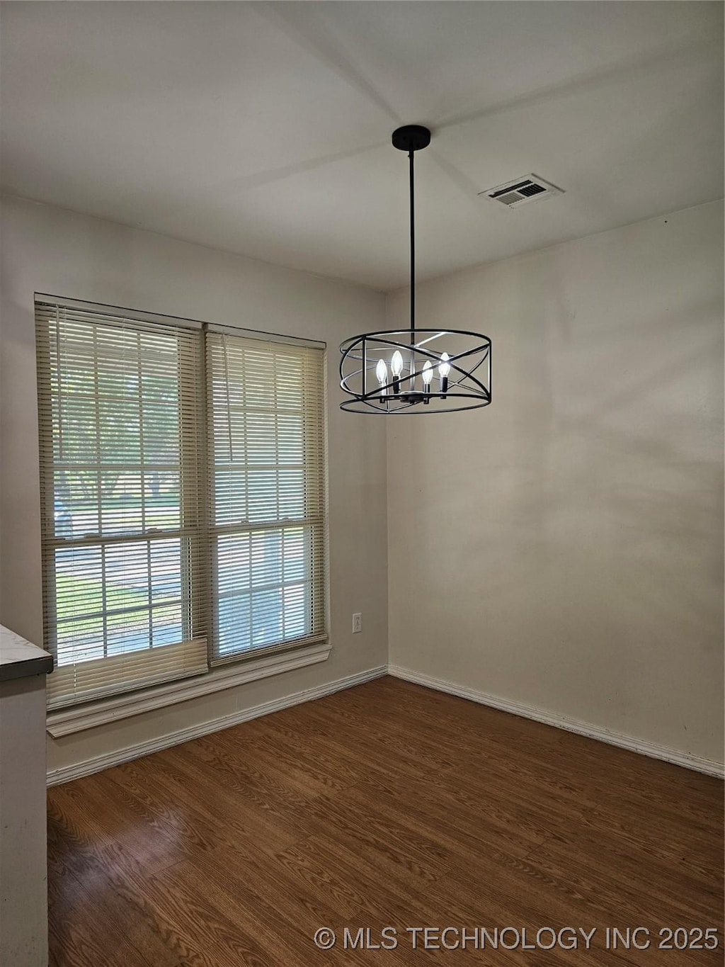 16211 E 109th St N, Owasso, OK 74055 - unfurnished dining area featuring wood finished floors and a chandelier