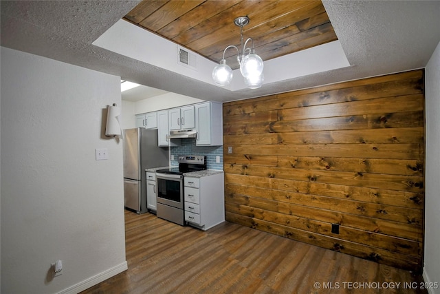 6370 S 80th E Ave Unit E, Tulsa, OK 74133 - kitchen with appliances with stainless steel finishes, under cabinet range hood, dark wood-style floors, decorative backsplash, and hanging light fixtures