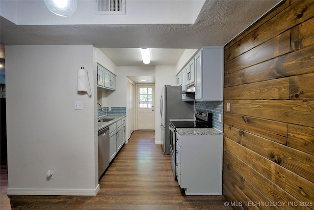 6370 S 80th E Ave Unit E, Tulsa, OK 74133 - kitchen featuring stainless steel appliances, backsplash, dark wood-type flooring, a textured ceiling, and under cabinet range hood