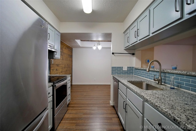 6370 S 80th E Ave Unit E, Tulsa, OK 74133 - kitchen featuring stainless steel appliances, backsplash, dark wood finished floors, range hood, and light stone counters
