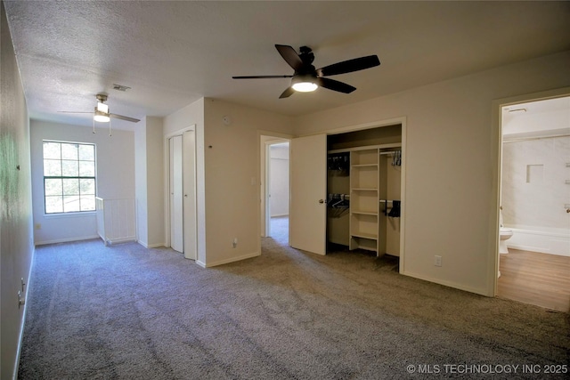 6370 S 80th E Ave Unit E, Tulsa, OK 74133 - unfurnished bedroom with two closets, carpet floors, ensuite bath, a ceiling fan, and a textured ceiling