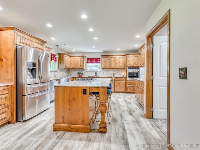 30833 S 4190th Rd, Inola, OK 74006 - kitchen with stainless steel appliances, a kitchen island, light wood-type flooring, decorative backsplash, and recessed lighting
