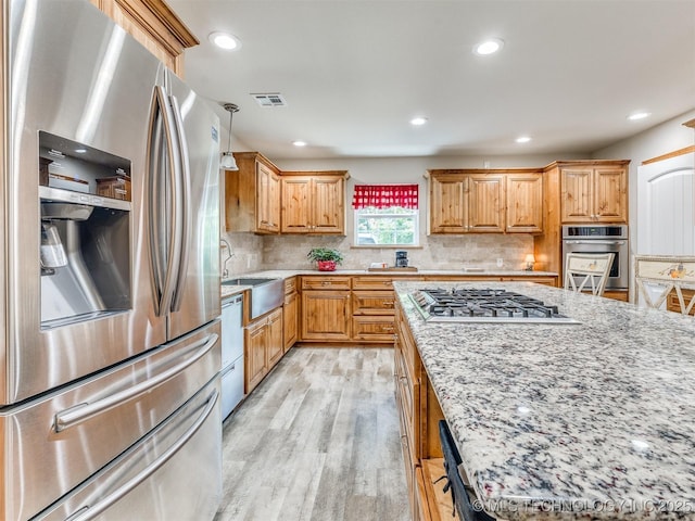 30833 S 4190th Rd, Inola, OK 74006 - kitchen featuring appliances with stainless steel finishes, light wood-type flooring, light stone countertops, backsplash, and recessed lighting
