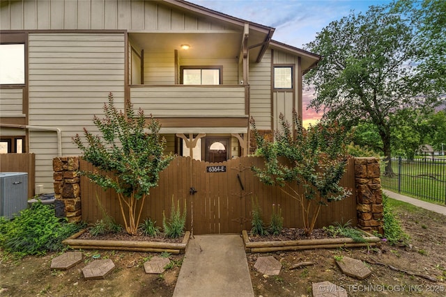 6364 S 80th E Ave Unit 34E, Tulsa, OK 74133 - view of front of house with a balcony, a gate, and board and batten siding