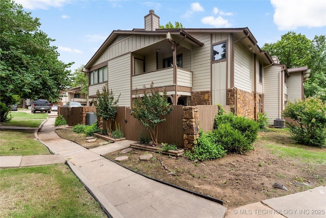 6364 S 80th E Ave Unit 34E, Tulsa, OK 74133 - view of side of property with a chimney, a balcony, and stone siding