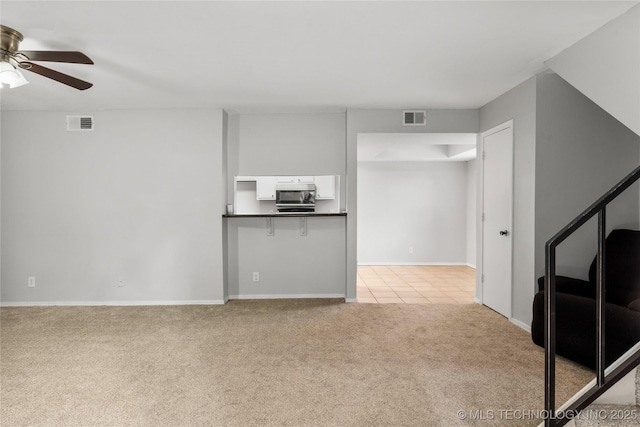 6364 S 80th E Ave Unit 34E, Tulsa, OK 74133 - unfurnished living room featuring light colored carpet, a ceiling fan, and light tile patterned floors