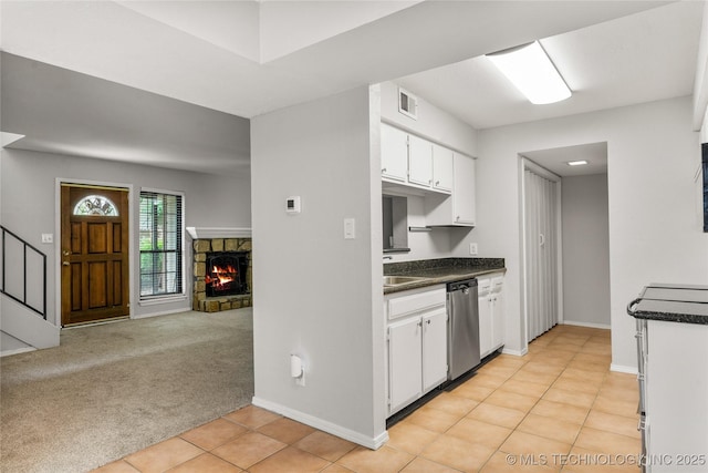 6364 S 80th E Ave Unit 34E, Tulsa, OK 74133 - kitchen with dishwasher, dark countertops, white cabinetry, and a fireplace