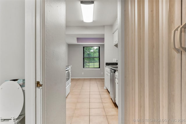 6364 S 80th E Ave Unit 34E, Tulsa, OK 74133 - kitchen with light tile patterned floors, stainless steel dishwasher, white cabinetry, range, and dark countertops