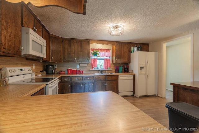 9730 S 4050th Rd, Talala, OK 74080 - kitchen featuring white appliances, light countertops, light wood-style flooring, a textured ceiling, and decorative backsplash