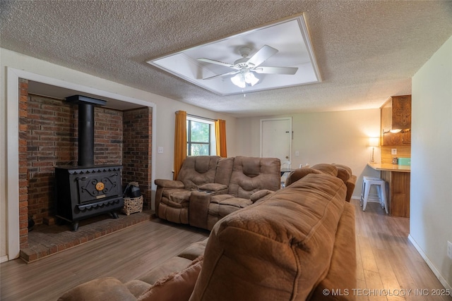 9730 S 4050th Rd, Talala, OK 74080 - living room with a textured ceiling, wood finished floors, a ceiling fan, and a wood stove