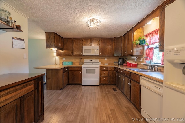 9730 S 4050th Rd, Talala, OK 74080 - kitchen with white appliances, a textured ceiling, light wood finished floors, backsplash, and light countertops