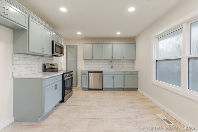4138 E 36th St, Tulsa, OK 74135 - kitchen with appliances with stainless steel finishes, recessed lighting, light countertops, decorative backsplash, and gray cabinets