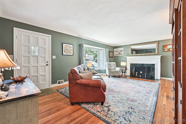 1347 E 37th St, Tulsa, OK 74105 - living area featuring crown molding, wood finished floors, a fireplace, and a textured ceiling
