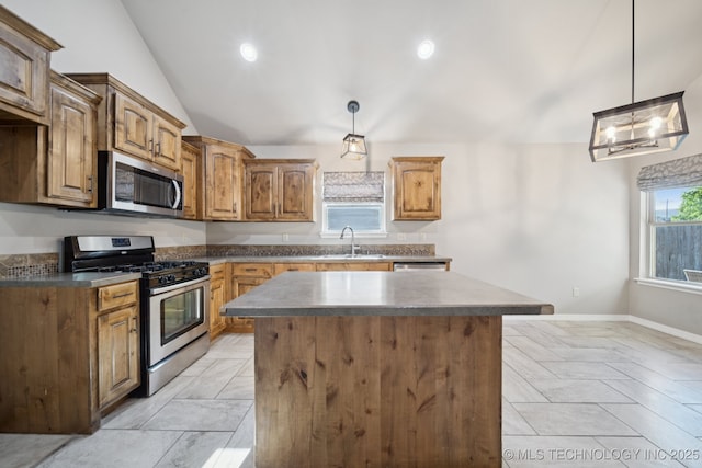 311 E 4th St, Skiatook, OK 74070 - kitchen featuring stainless steel appliances, a center island, lofted ceiling, dark countertops, and decorative light fixtures