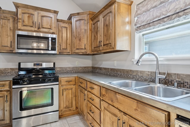 311 E 4th St, Skiatook, OK 74070 - kitchen featuring stainless steel appliances, brown cabinets, and light tile patterned floors