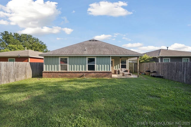311 E 4th St, Skiatook, OK 74070 - back of house featuring brick siding, roof with shingles, board and batten siding, and a fenced backyard