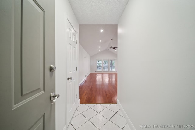 13111 E 80th St N, Owasso, OK 74055 - corridor featuring lofted ceiling, light tile patterned flooring, and a textured ceiling