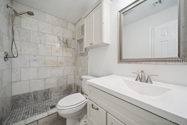 13111 E 80th St N, Owasso, OK 74055 - bathroom with tiled shower, vanity, and a textured ceiling