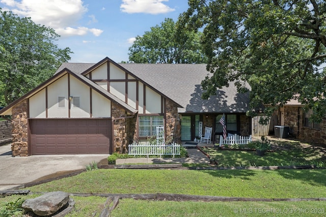 2519 W 53rd St, Tulsa, OK 74107 - tudor house with stone siding, an attached garage, driveway, a front lawn, and a shingled roof