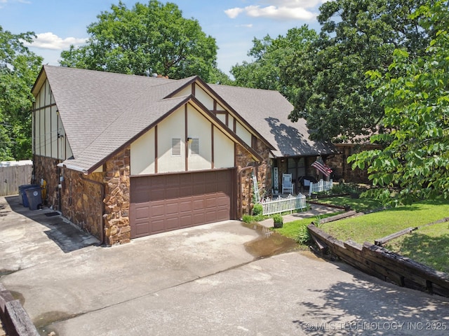 2519 W 53rd St, Tulsa, OK 74107 - tudor house with stone siding, a shingled roof, a garage, and concrete driveway