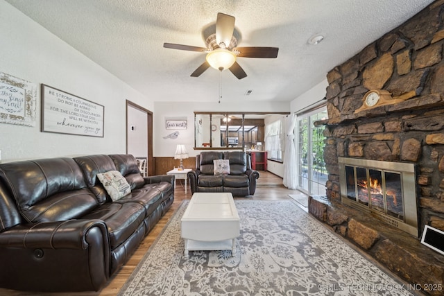 2519 W 53rd St, Tulsa, OK 74107 - living room featuring a textured ceiling, wood finished floors, a ceiling fan, and a fireplace