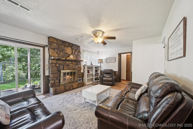 2519 W 53rd St, Tulsa, OK 74107 - living room featuring a textured ceiling, ceiling fan, a fireplace, and wood finished floors