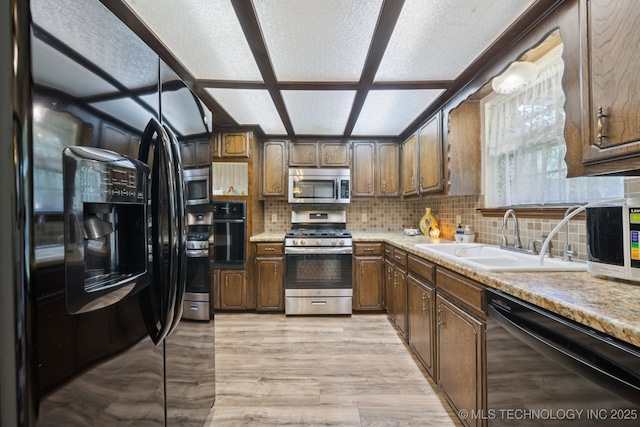 2519 W 53rd St, Tulsa, OK 74107 - kitchen with black appliances, light countertops, decorative backsplash, and light wood-style floors