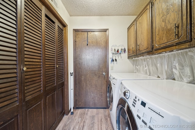 2519 W 53rd St, Tulsa, OK 74107 - washroom with washing machine and dryer, cabinet space, light wood-style floors, and a textured ceiling