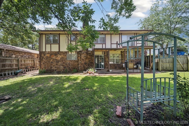 2519 W 53rd St, Tulsa, OK 74107 - rear view of property featuring stone siding, a fenced backyard, and a patio