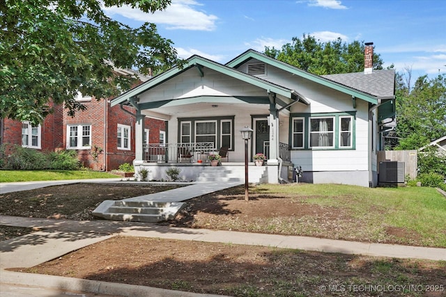 1144 S Owasso Ave, Tulsa, OK 74120 - view of front facade with covered porch, a chimney, and a front lawn