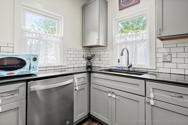 1144 S Owasso Ave, Tulsa, OK 74120 - kitchen featuring stainless steel dishwasher, gray cabinetry, dark countertops, and healthy amount of natural light