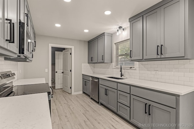 9421 S 69th E Ave, Tulsa, OK 74133 - kitchen with stainless steel appliances, gray cabinets, recessed lighting, tasteful backsplash, and light wood-style flooring