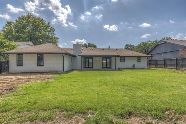 9421 S 69th E Ave, Tulsa, OK 74133 - back of house featuring a chimney, brick siding, and roof with shingles