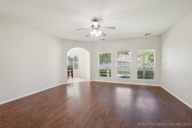 2109 W Maple St, Collinsville, OK 74021 - unfurnished living room featuring arched walkways, a ceiling fan, and wood finished floors
