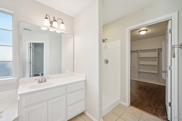 2109 W Maple St, Collinsville, OK 74021 - full bath featuring vanity, a tile shower, a spacious closet, tile patterned flooring, and plenty of natural light