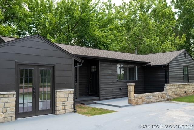 4621 Riverside Dr, Tulsa, OK 74105 - ranch-style home featuring stone siding, french doors, and a shingled roof