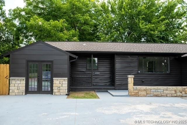4621 Riverside Dr, Tulsa, OK 74105 - view of front facade with french doors, stone siding, and a shingled roof