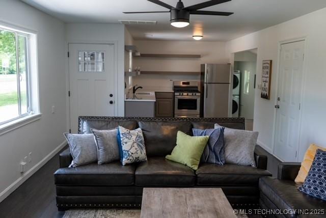 4621 Riverside Dr, Tulsa, OK 74105 - living area featuring stacked washer / dryer, ceiling fan, healthy amount of natural light, and wood finished floors