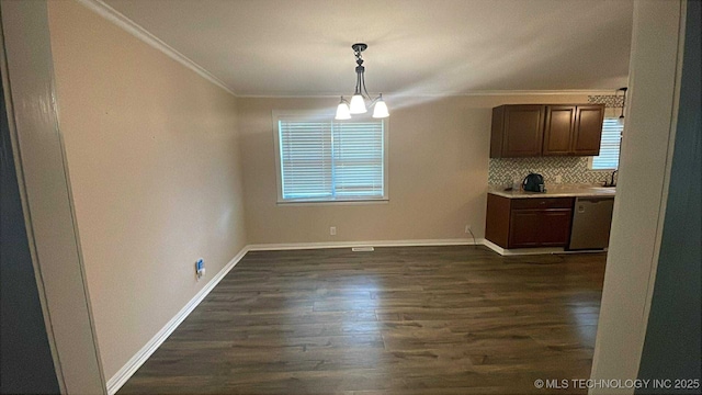 219 N Anthony St, Muskogee, OK 74403 - unfurnished dining area featuring ornamental molding, dark wood-style flooring, and a chandelier