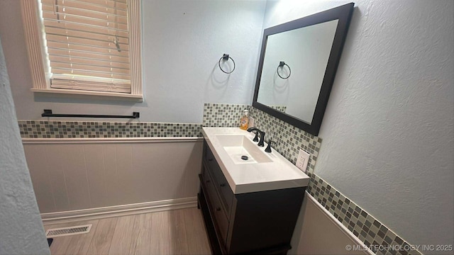 219 N Anthony St, Muskogee, OK 74403 - bathroom with vanity, wood finished floors, and wainscoting