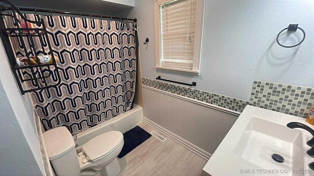219 N Anthony St, Muskogee, OK 74403 - bathroom with vanity, shower / bath combination with curtain, and wainscoting