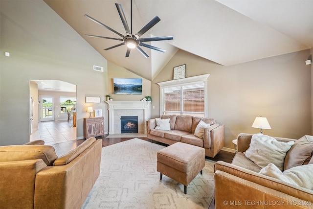 13037 N 124th E Pl, Collinsville, OK 74021 - living area with ceiling fan, a tiled fireplace, arched walkways, light wood-type flooring, and high vaulted ceiling